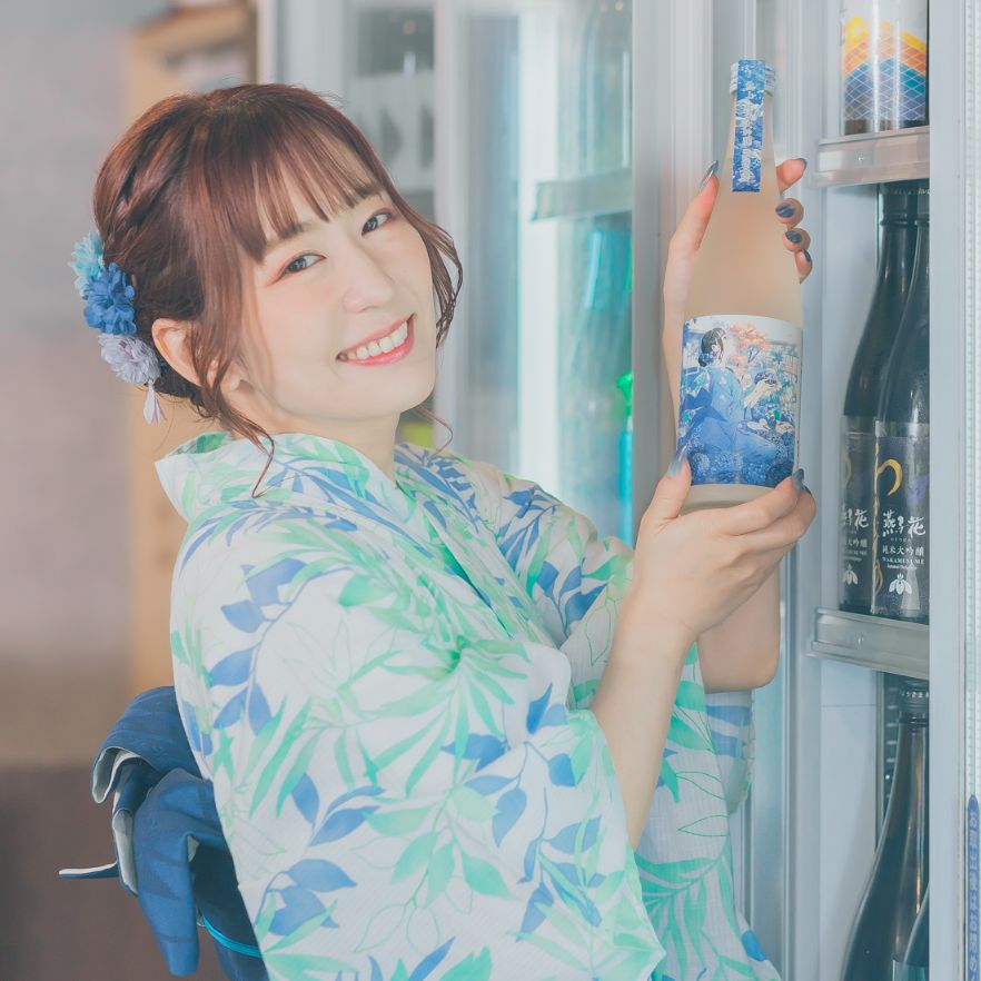 日本酒 真上 紫陽花櫻のボトルを持つ笑顔の櫻川めぐ